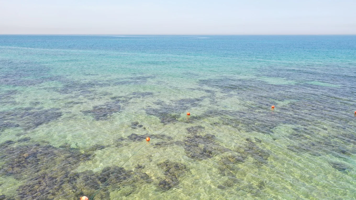 Clear turquoise water with orange buoys at Jiyeh